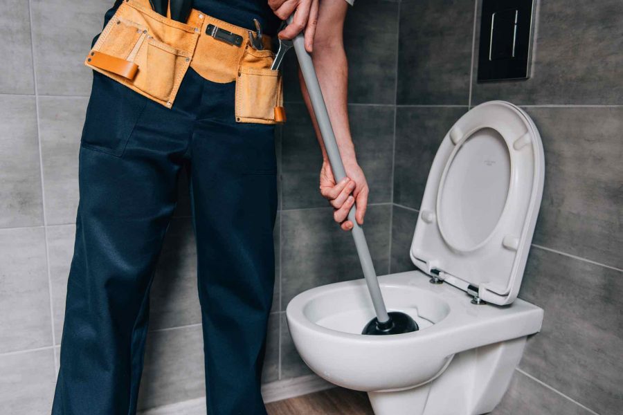 partial-view-of-male-plumber-using-plunger-and-cle-JGX48K8.jpg